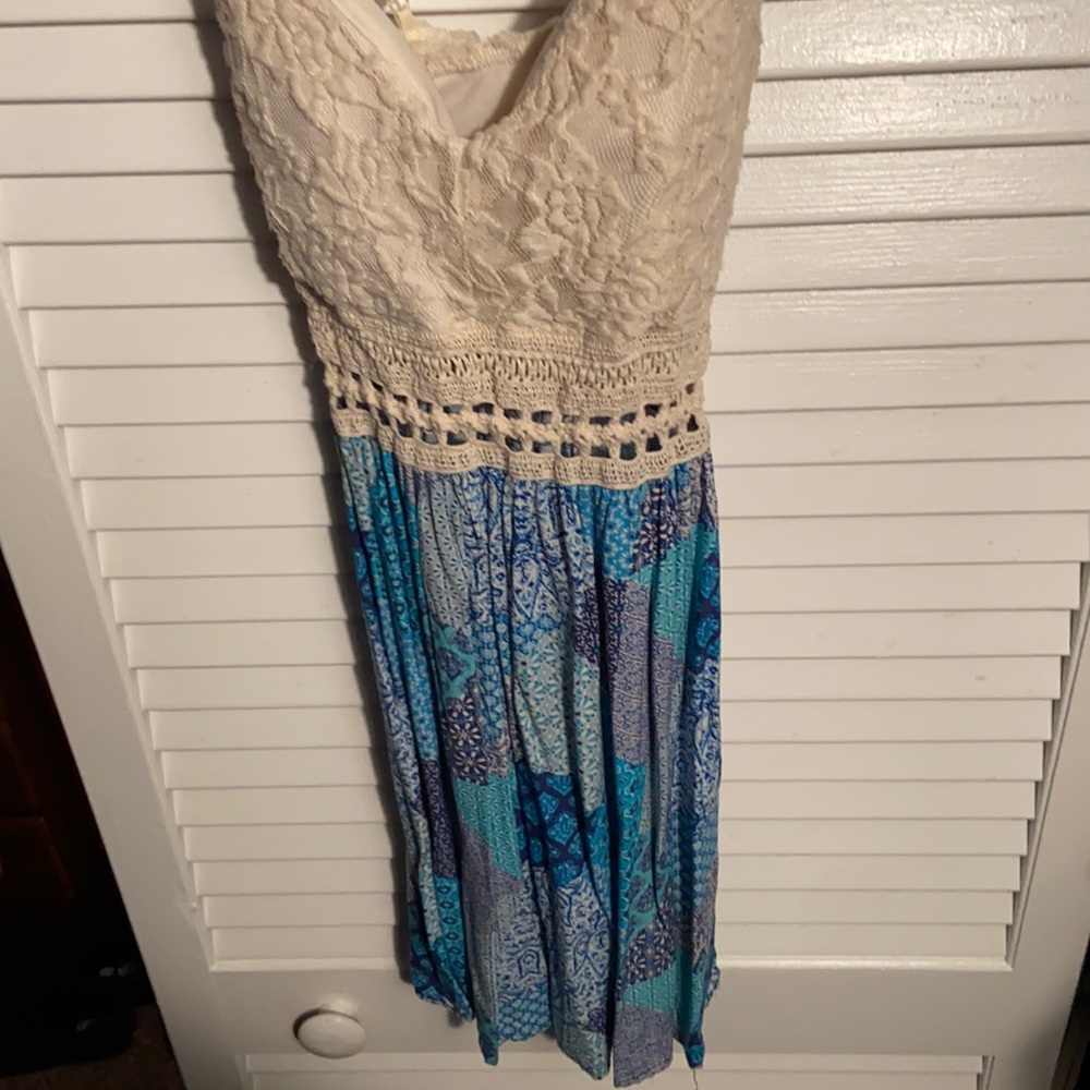 Cream and blue patterned short dress. Straps crisscross in the back.